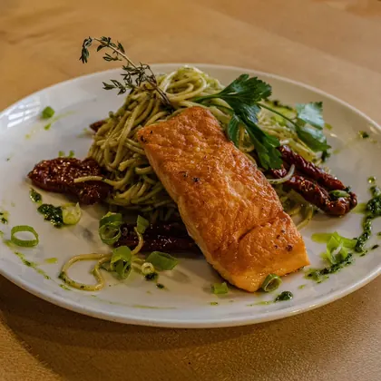 Gebratener Fisch mit Gemüse auf weißem Teller