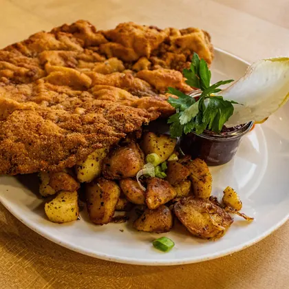 Paniertes Schnitzel mit Bratkartoffeln und Zitrone